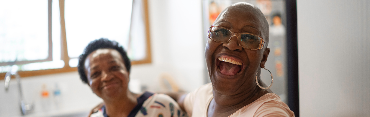 Two women taking a selfie, smiling widely at the camera.