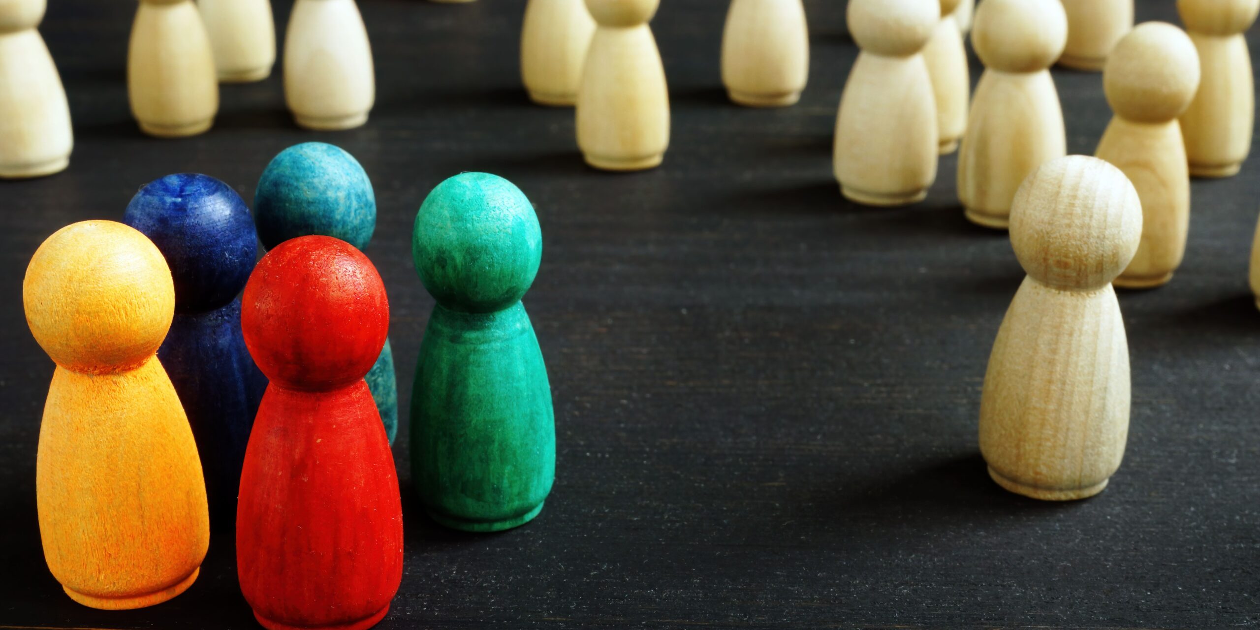 A photo of wooden pegs, some of them are coloured brightly and some aren't. They are segmented into groups