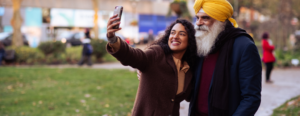 An older and younger person taking a selfie together.