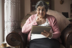 A woman laughs as she uses an ipad